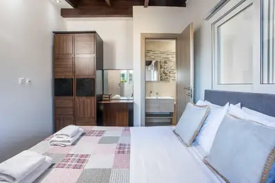 a bedroom with a large bed and a bathroom at Kalimera Villa By the Sea in Gennadi