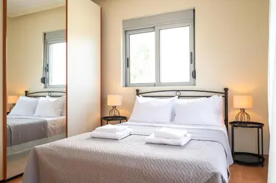 a bedroom with a bed with two towels on it at Villa De Ella in Ialyssos