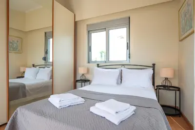 a bedroom with a bed with two towels on it at Villa De Ella in Ialyssos