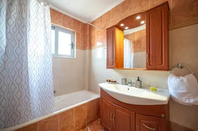 a bathroom with a sink and a bath tub at Villa De Ella in Ialyssos