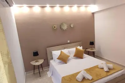 a bedroom with a large white bed with two tables at Tilos Pearl in Livadia