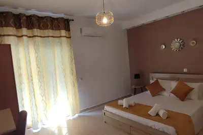 a bedroom with a large bed and a window at Tilos Pearl in Livadia