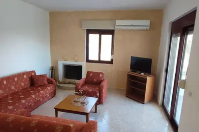a living room with a couch and a tv at Tilos Pearl in Livadia