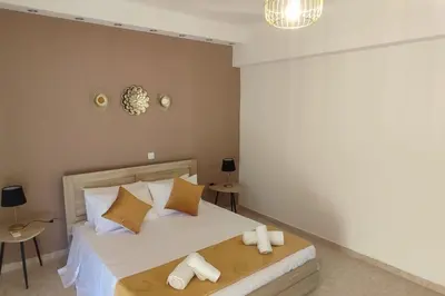a bedroom with a large white bed with pillows at Tilos Pearl in Livadia