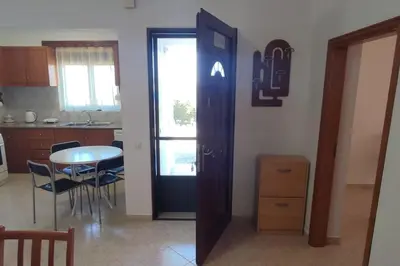a kitchen and dining room with a table and a door at Tilos Pearl in Livadia