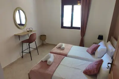 a bedroom with a large bed and a mirror at Tilos Pearl in Livadia