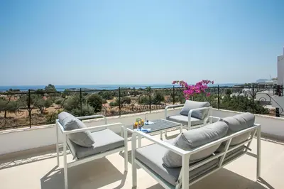 a balcony with two chairs and a table on a roof at Exclusive Olive & Herb Villa, Mountain to Sea Views, Rhodes in Afantou