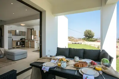 a living room with a table with food on it at Exclusive Olive & Herb Villa, Mountain to Sea Views, Rhodes in Afantou