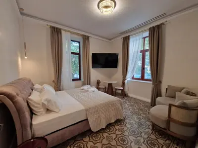 a bedroom with a bed and a couch and a chair at Jensen Luxury Suites in Rhodes Town
