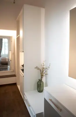 a kitchen with white cabinets and a vase with flowers at Jensen Luxury Suites in Rhodes Town