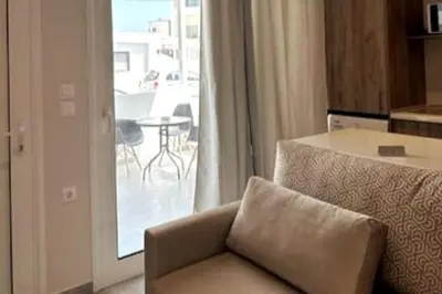 a living room with a couch and a view of a patio at Nirea studio in Faliraki Rhodes in Faliraki