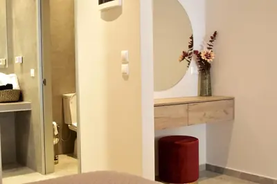 a bathroom with a mirror and a vase with flowers at Nirea studio in Faliraki Rhodes in Faliraki