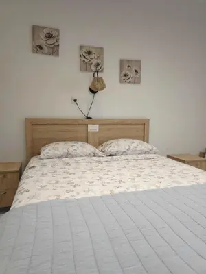 a bedroom with a white bed with two pictures on the wall at Tina's Studio in Pastida