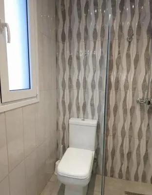 a bathroom with a toilet and a shower curtain at Tina's Studio in Pastida