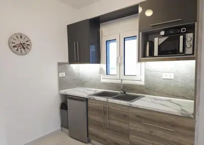 a kitchen with a sink and a microwave at Tina's Studio in Pastida