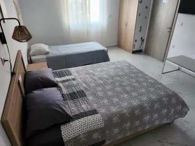 a bedroom with two beds and a lamp at Tina's Studio in Pastida