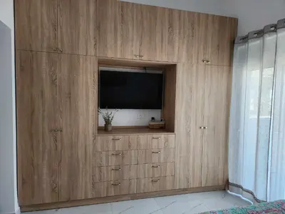 a large wooden entertainment center with a flat screen tv at Gianna's Studio in Pastida