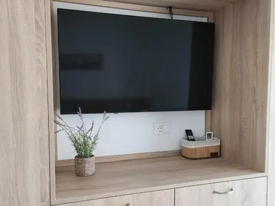 a large flat screen tv sitting on top of a cabinet at Gianna's Studio in Pastida