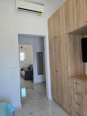a living room with a tv and a large wooden cabinet at Gianna's Studio in Pastida
