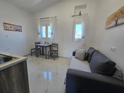 a living room with a couch and a table at Gianna's Studio in Pastida