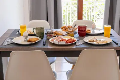 a wooden table with plates of food and drinks at Residence City Apartment in Rhodes Town