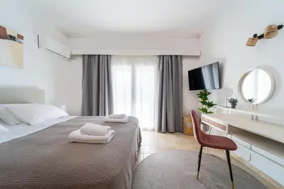a bedroom with a bed and a chair and a mirror at Residence City Apartment in Rhodes Town