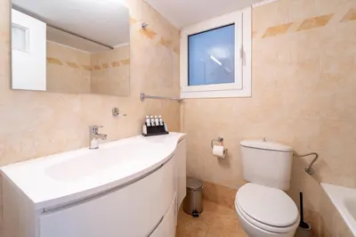 a bathroom with a toilet and a sink and a window at Residence City Apartment in Rhodes Town