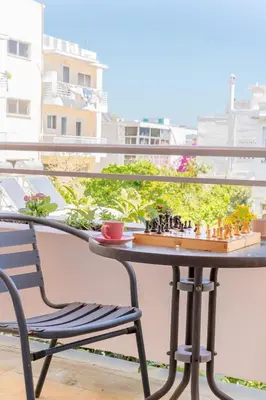 a chess board on a table on a balcony with a chair at Residence City Apartment in Rhodes Town