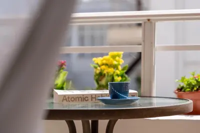 a glass table with a blue cup and flowers on it at Residence City Apartment in Rhodes Town