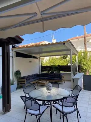 a patio with a table and chairs under an umbrella at John's house in Rhodes Town