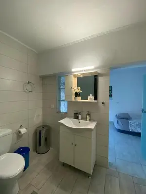 a bathroom with a sink and a toilet and a bed at John's house in Rhodes Town