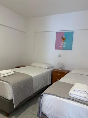 a bedroom with two beds and a picture on the wall at John's house in Rhodes Town