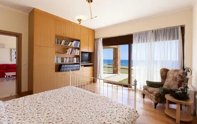 a bedroom with a bed and a view of the ocean at Private beach villa Princess in Kiotari