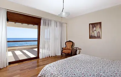a bedroom with a bed and a view of the ocean at Private beach villa Princess in Kiotari