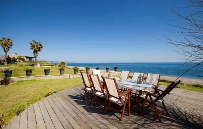 a table and chairs sitting on a deck overlooking the ocean at Private beach villa Princess in Kiotari