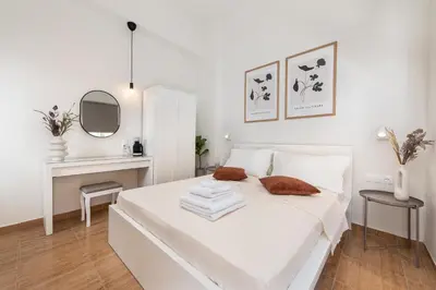 a white bedroom with a white bed and a mirror at Fani's City Apartment in Rhodes Town