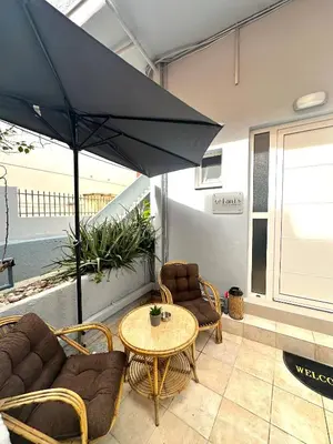 a patio with a table and chairs and an umbrella at Fani's City Apartment in Rhodes Town