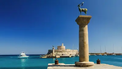 a statue of a goat on a column in the water at Fani's City Apartment in Rhodes Town