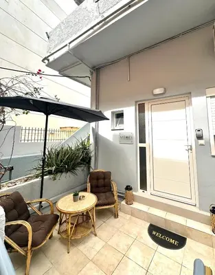 a patio with a table and chairs and an umbrella at Fani's City Apartment in Rhodes Town