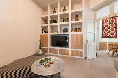 a living room with a bed and a tv at Lemontrees Residences in Rhodes Town