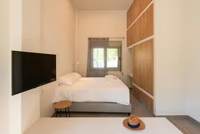 a small bedroom with a bed and a flat screen tv at Lemontrees Residences in Rhodes Town