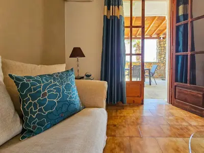 a living room with a couch with a blue pillow at George Seaside Serviced Studios & Apartments in Pefki Rhodes