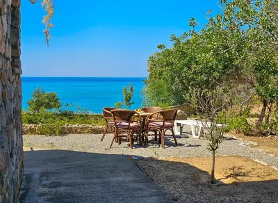 a group of chairs sitting around a table near the ocean at George Seaside Serviced Studios & Apartments in Pefki Rhodes