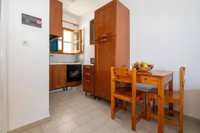 a kitchen with a wooden table with a bowl of fruit on it at George Seaside Serviced Studios & Apartments in Pefki Rhodes