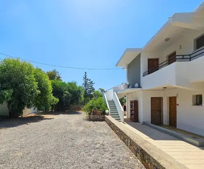 a large white house with a driveway at George Seaside Serviced Studios & Apartments in Pefki Rhodes