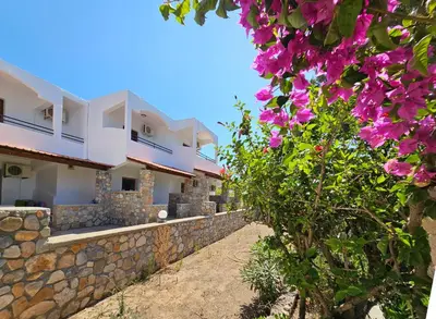 a view of a row of houses with pink flowers at George Seaside Serviced Studios & Apartments in Pefki Rhodes