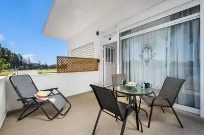a patio with a table and chairs on a balcony at Sokrates Apartments in Kolimbia