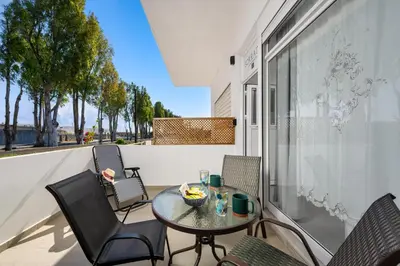 a patio with a table and chairs on a balcony at Sokrates Apartments in Kolimbia