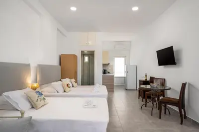 a living room with two beds and a dining room at Sokrates Apartments in Kolimbia