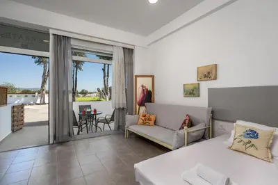 a living room with a couch and a balcony at Sokrates Apartments in Kolimbia